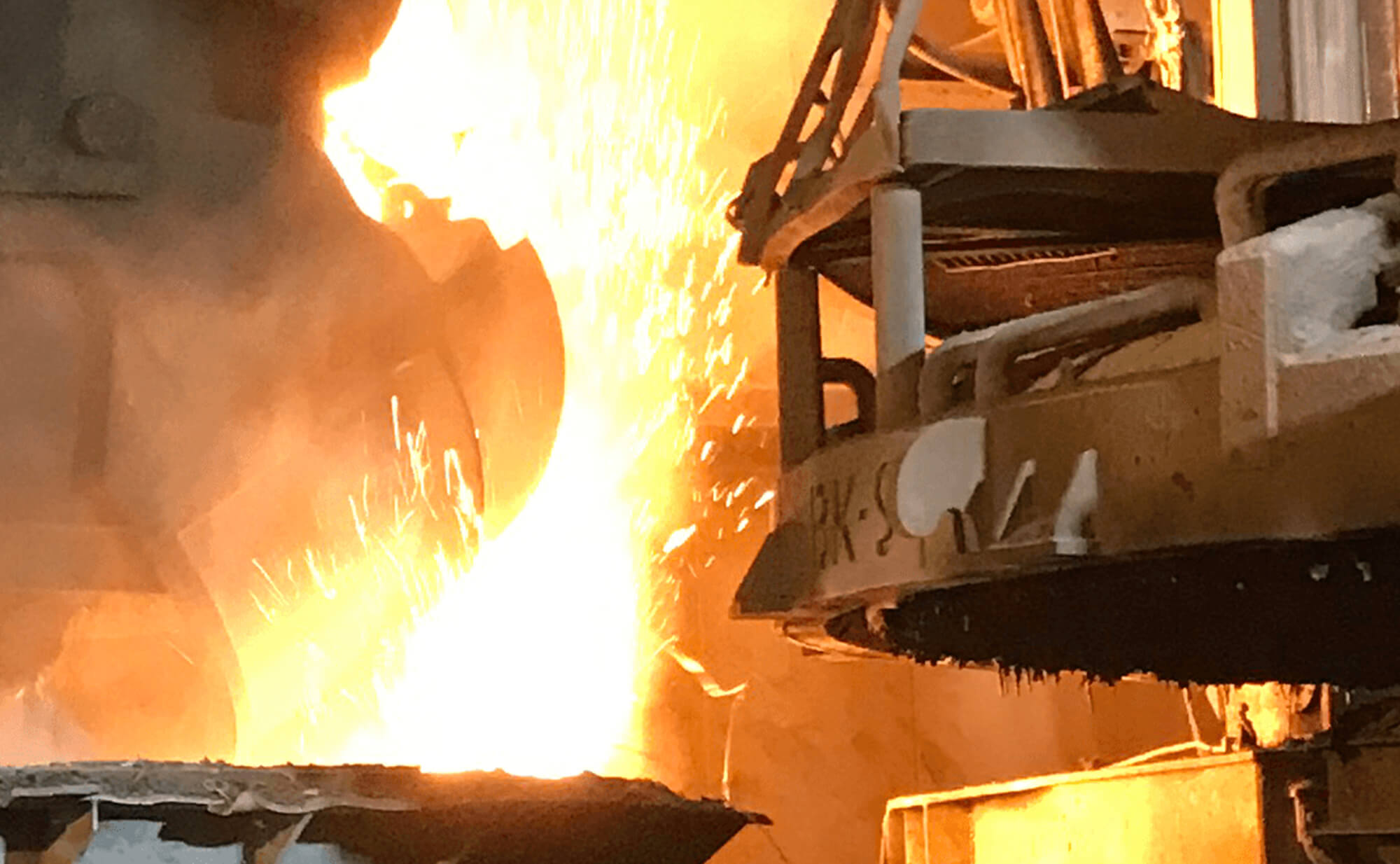 Photo depicting the charging of the E-oven in the steel production process